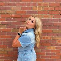 Female student standing in front of brick wall